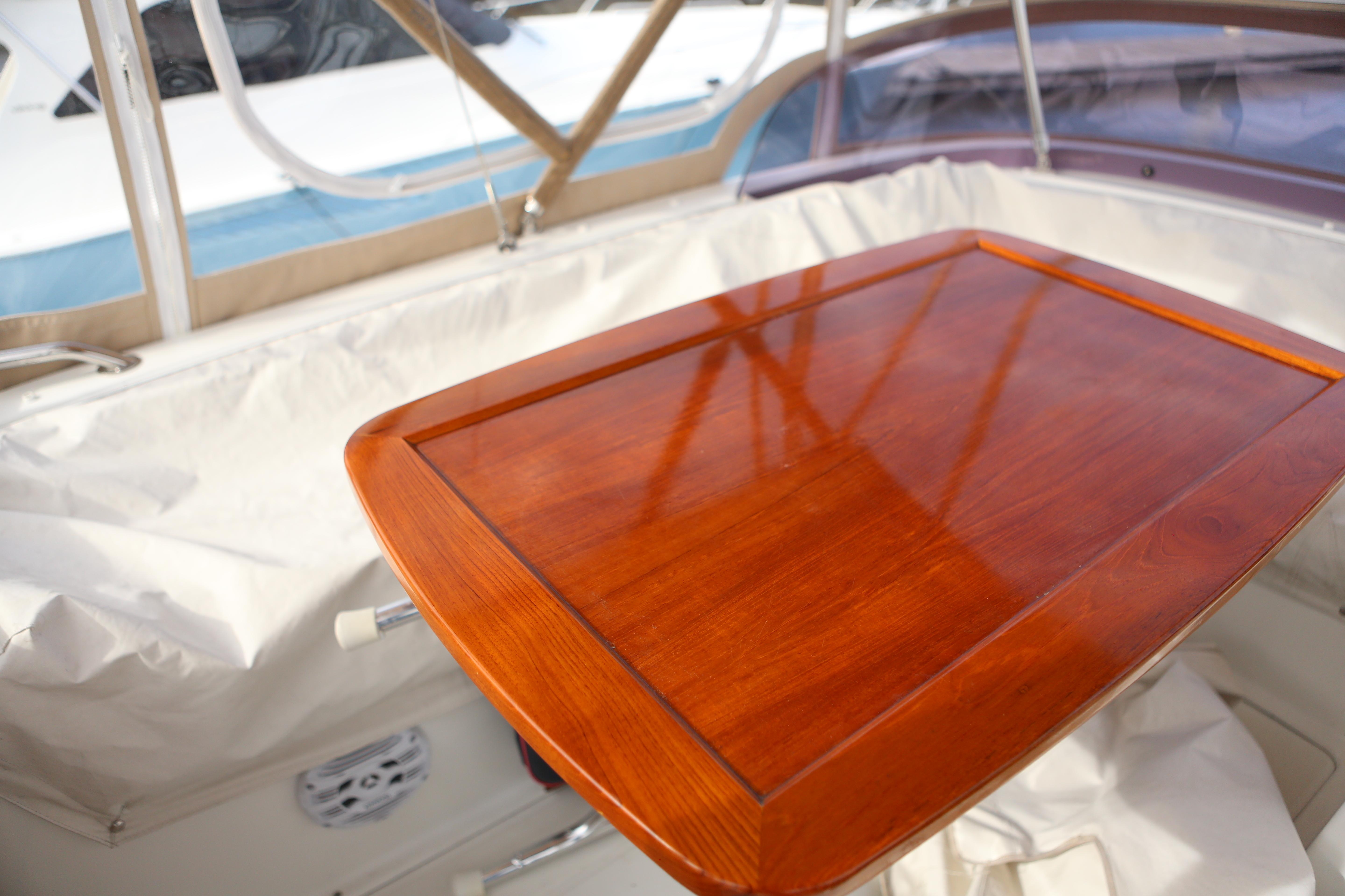 L-shaped seating and varnished table on flybridge