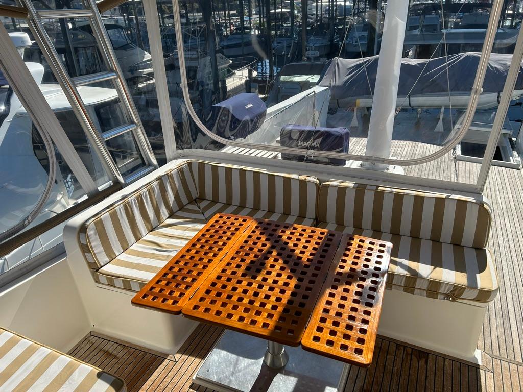 Enclosed Flybridge Seating Around Varnished Table